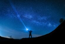 silhouette of man holding flashlight