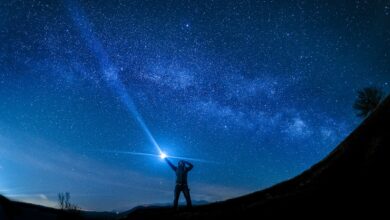 silhouette of man holding flashlight