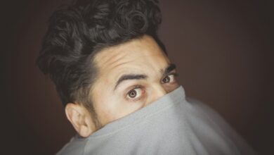 man covering his face with his crew-neck top