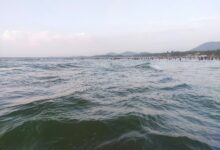 a large body of water with people in the distance