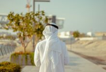 person in white robe standing on road during daytime