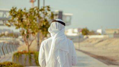 person in white robe standing on road during daytime