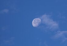 A clear blue sky with a half moon