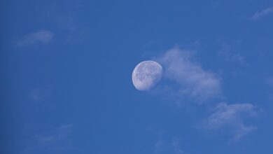 A clear blue sky with a half moon