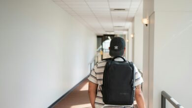a man walking down a hallway with a backpack on his back
