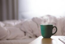 green ceramic mug on wooden desk