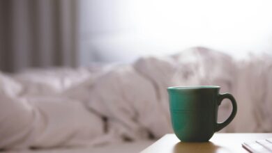 green ceramic mug on wooden desk