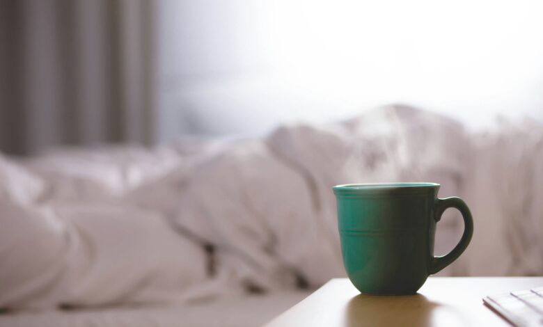 green ceramic mug on wooden desk