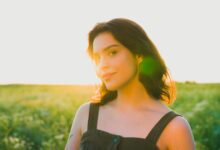 A woman standing in a field of green grass