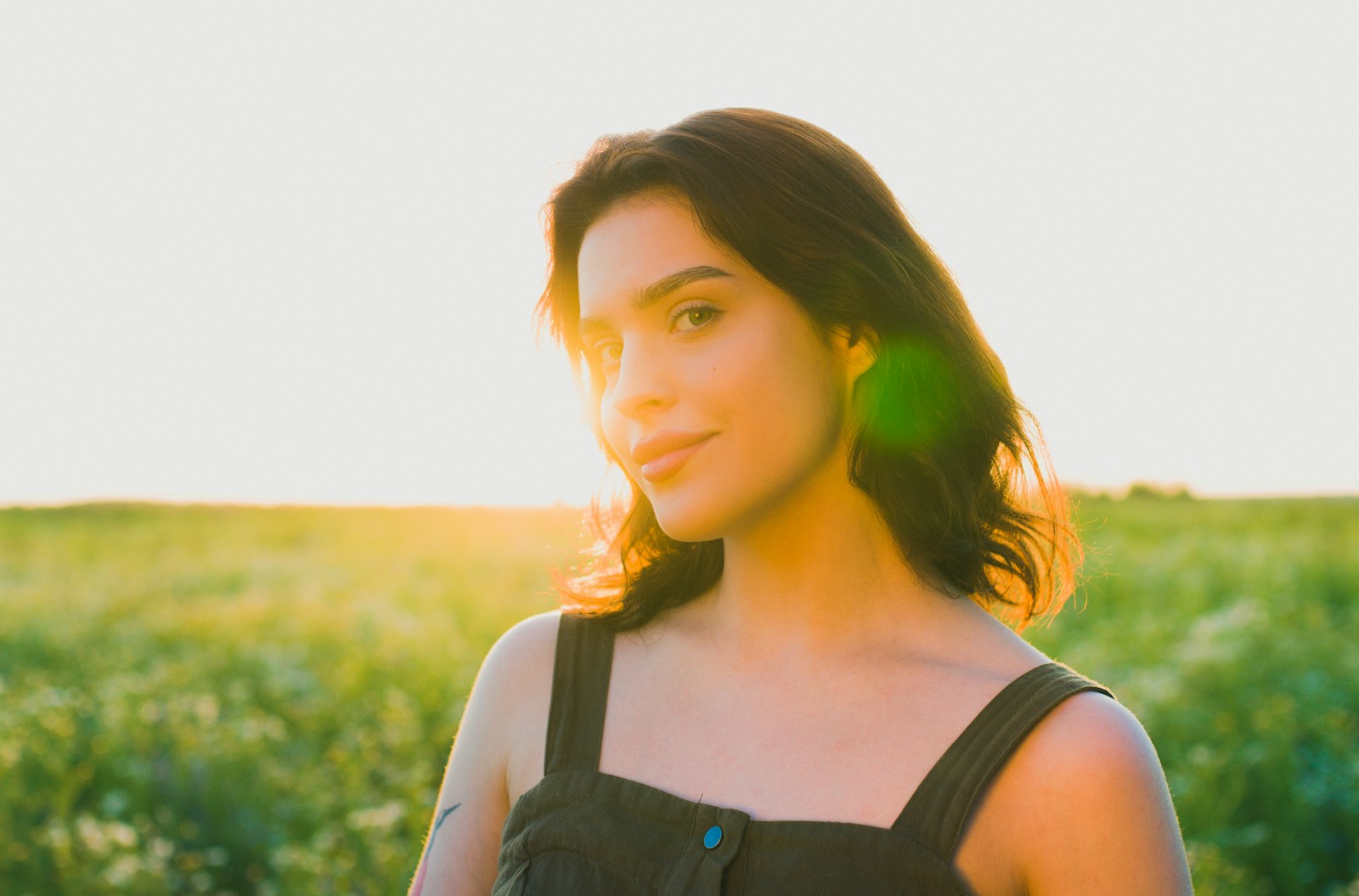 A woman standing in a field of green grass