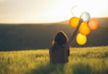 unknown person holding balloons outdoors