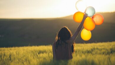 unknown person holding balloons outdoors