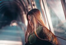 a woman with long hair standing in a tunnel