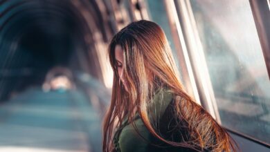 a woman with long hair standing in a tunnel