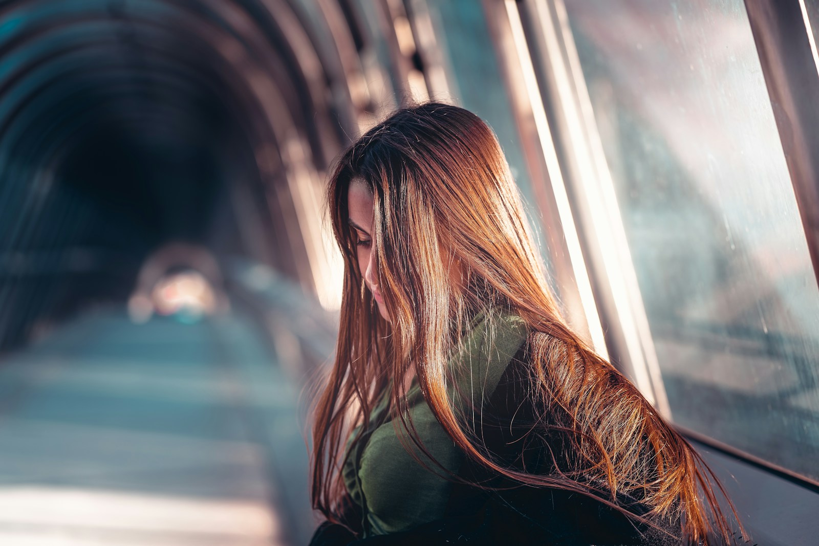 a woman with long hair standing in a tunnel