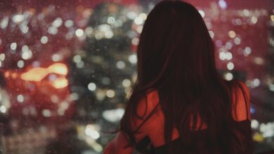 a woman looking out a window at a cityscape