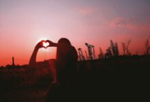 silhouette of man raising his hand during sunset
