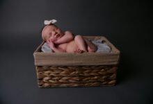 baby lying on brown wicker basket