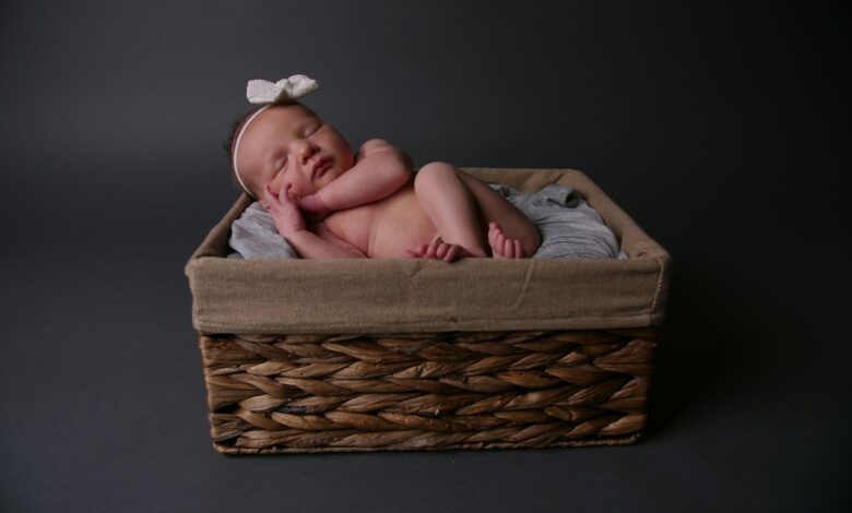 baby lying on brown wicker basket